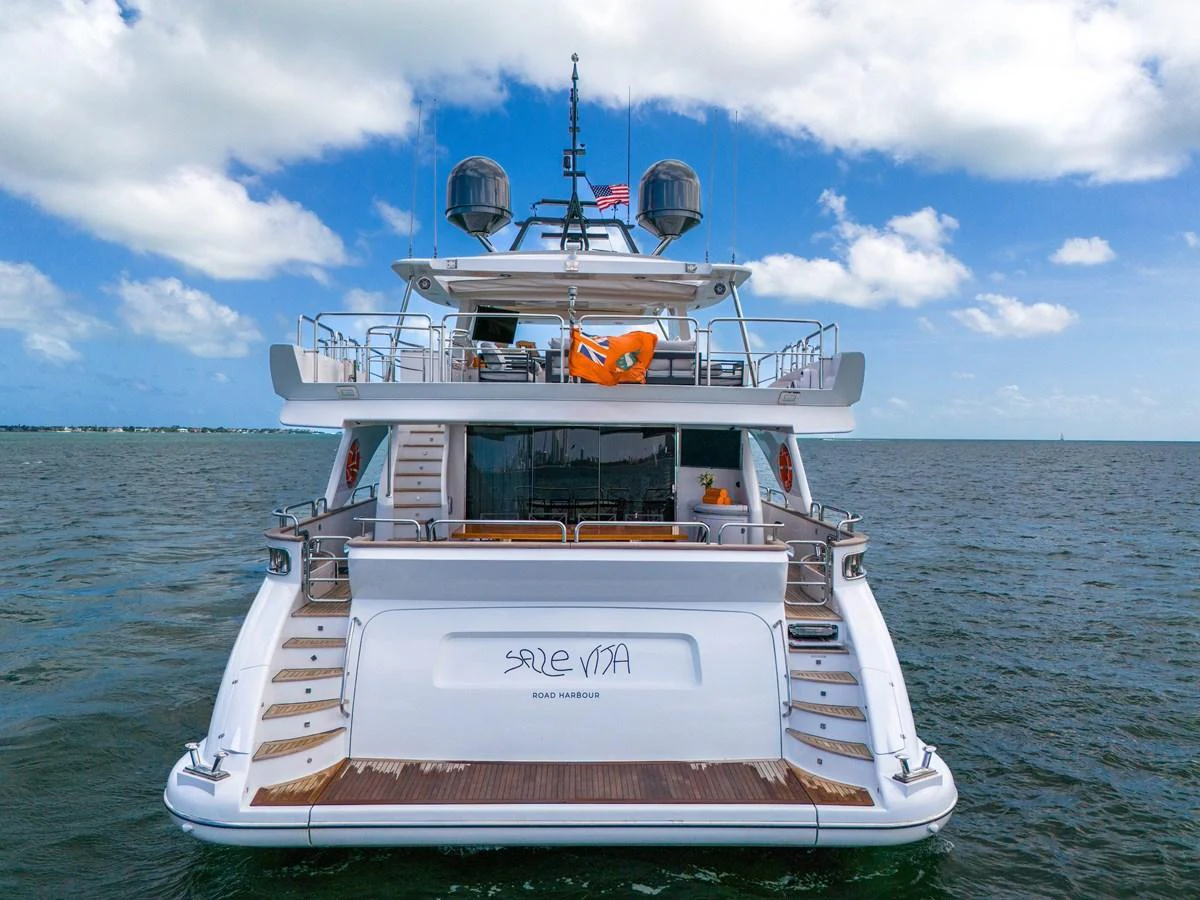 A luxurious yacht is anchored on calm waters, showcasing its elegant stern design and spacious decks. aboard AZIMUT GRANDE 105 Yacht for Sale