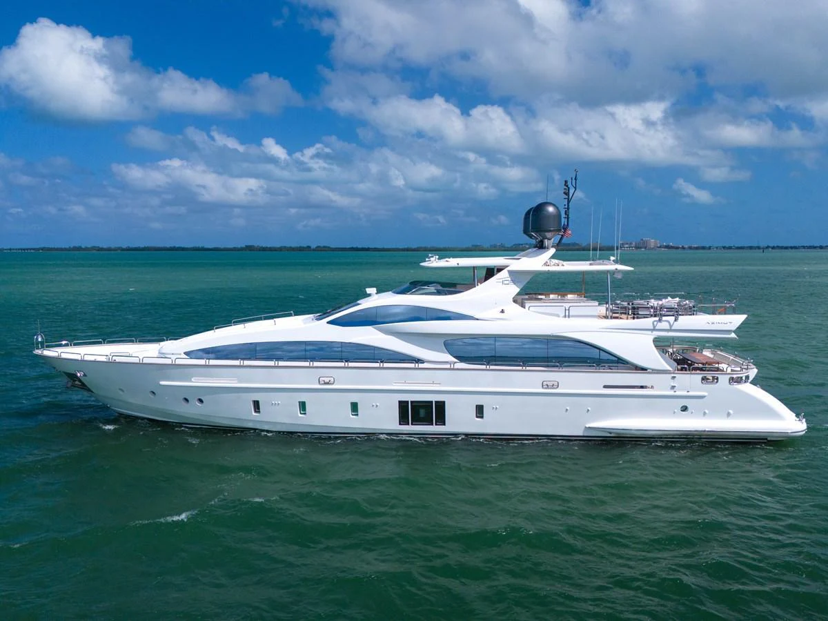 A sleek and modern yacht glides gracefully on calm waters under a clear blue sky. aboard AZIMUT GRANDE 105 Yacht for Sale