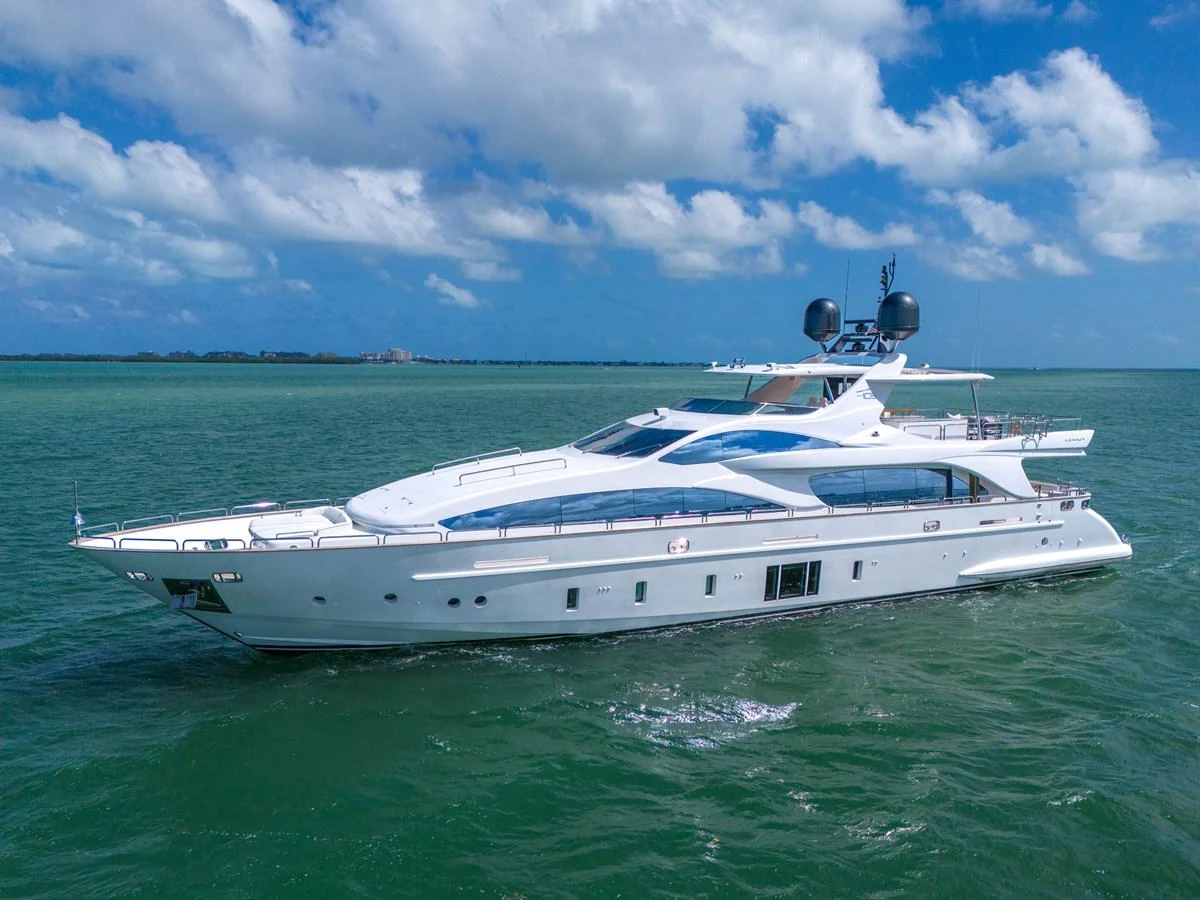 A sleek and modern yacht cruising on calm waters under a bright blue sky. aboard AZIMUT GRANDE 105 Yacht for Sale