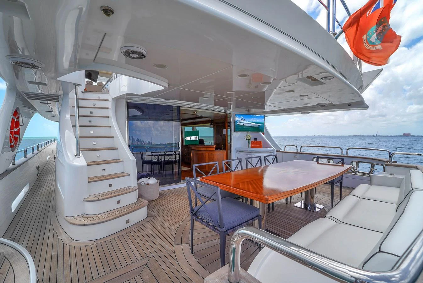 The yacht's aft deck features a spacious seating area with a dining table, perfect for alfresco dining and relaxation. aboard AZIMUT GRANDE 105 Yacht for Sale