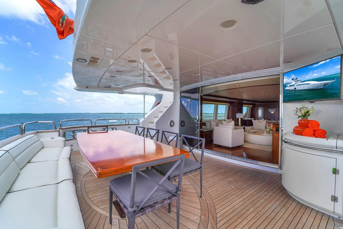 The aft deck features a spacious dining area with a view of the interior salon and the ocean. aboard AZIMUT GRANDE 105 Yacht for Sale