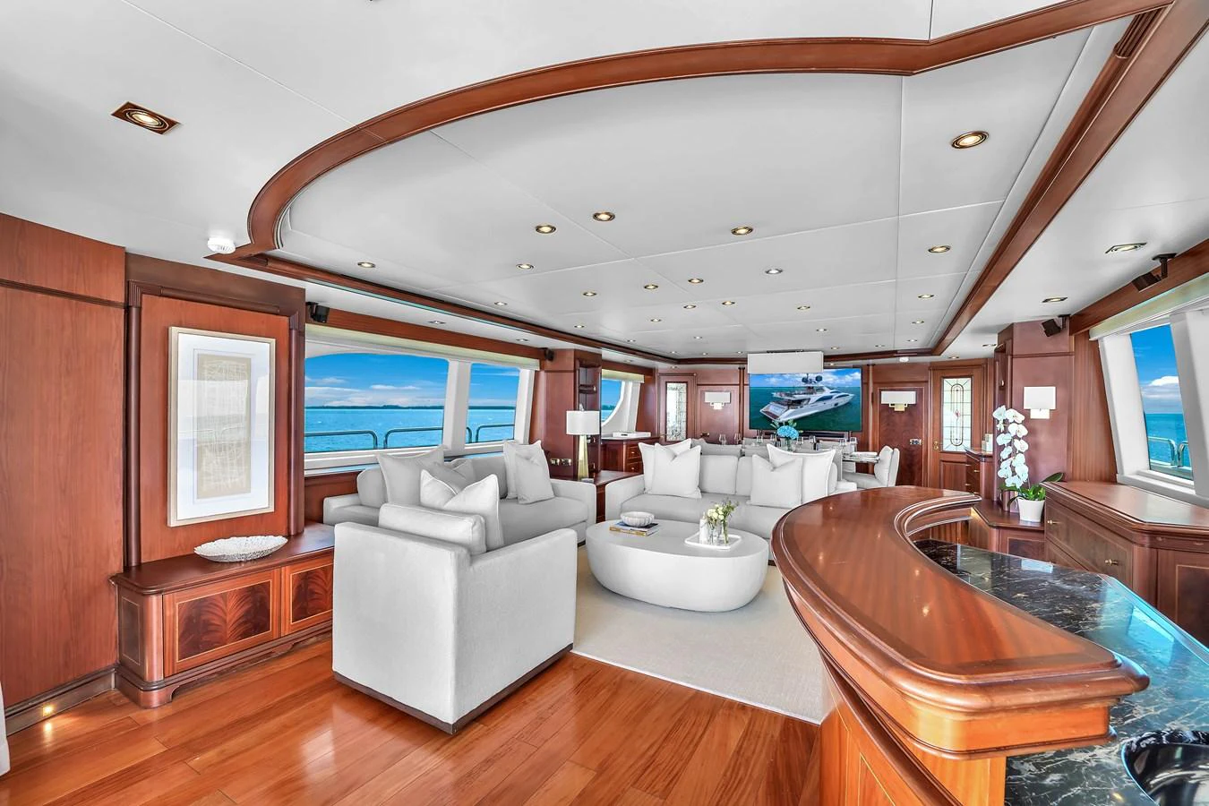 The salon features elegant wood finishes, plush seating, and large windows offering stunning ocean views. aboard AZIMUT GRANDE 105 Yacht for Sale