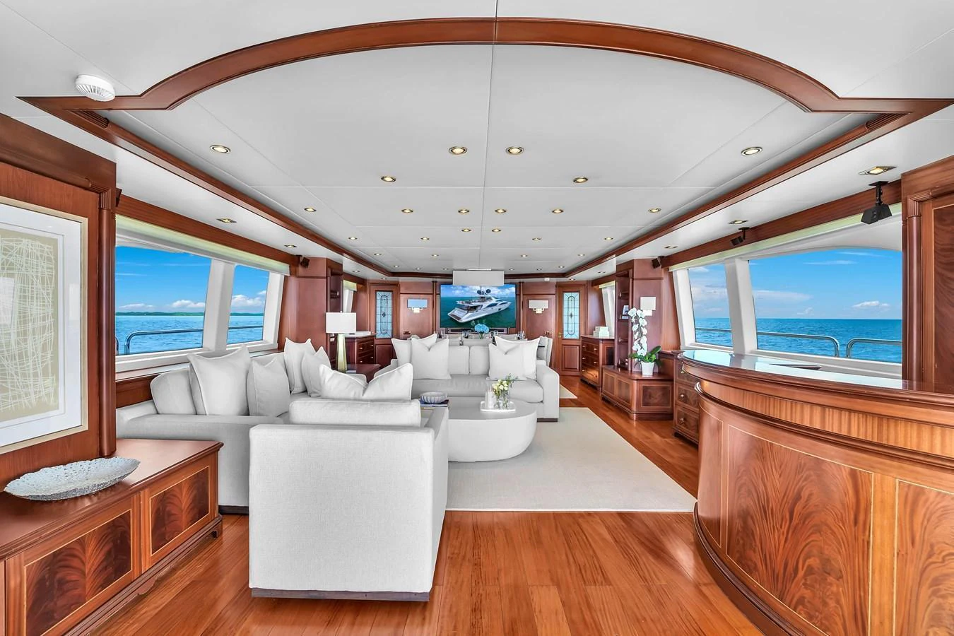 The salon features elegant wood finishes, plush seating, and large windows offering stunning ocean views. aboard AZIMUT GRANDE 105 Yacht for Sale