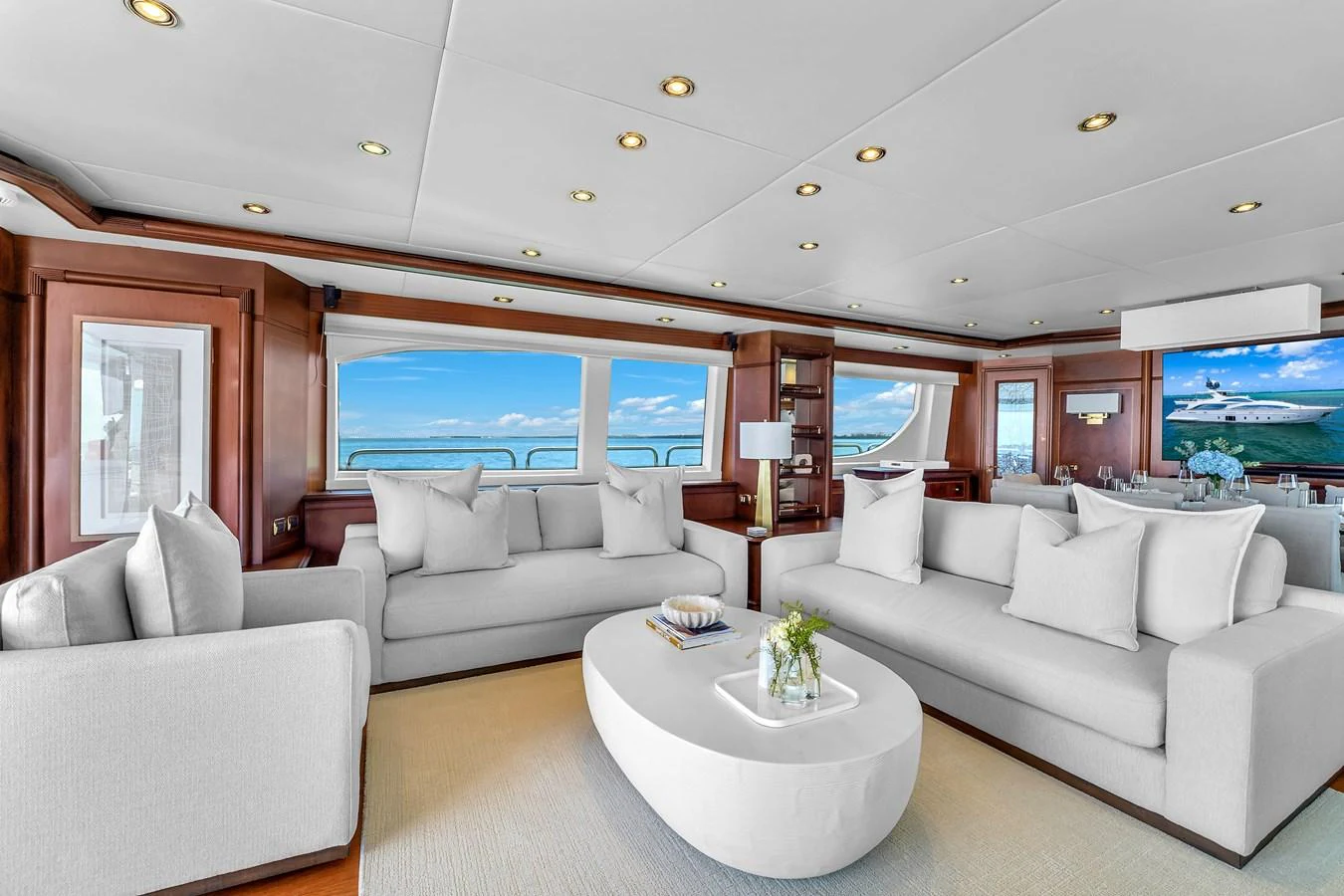 The salon features plush seating and expansive windows offering stunning ocean views. aboard AZIMUT GRANDE 105 Yacht for Sale