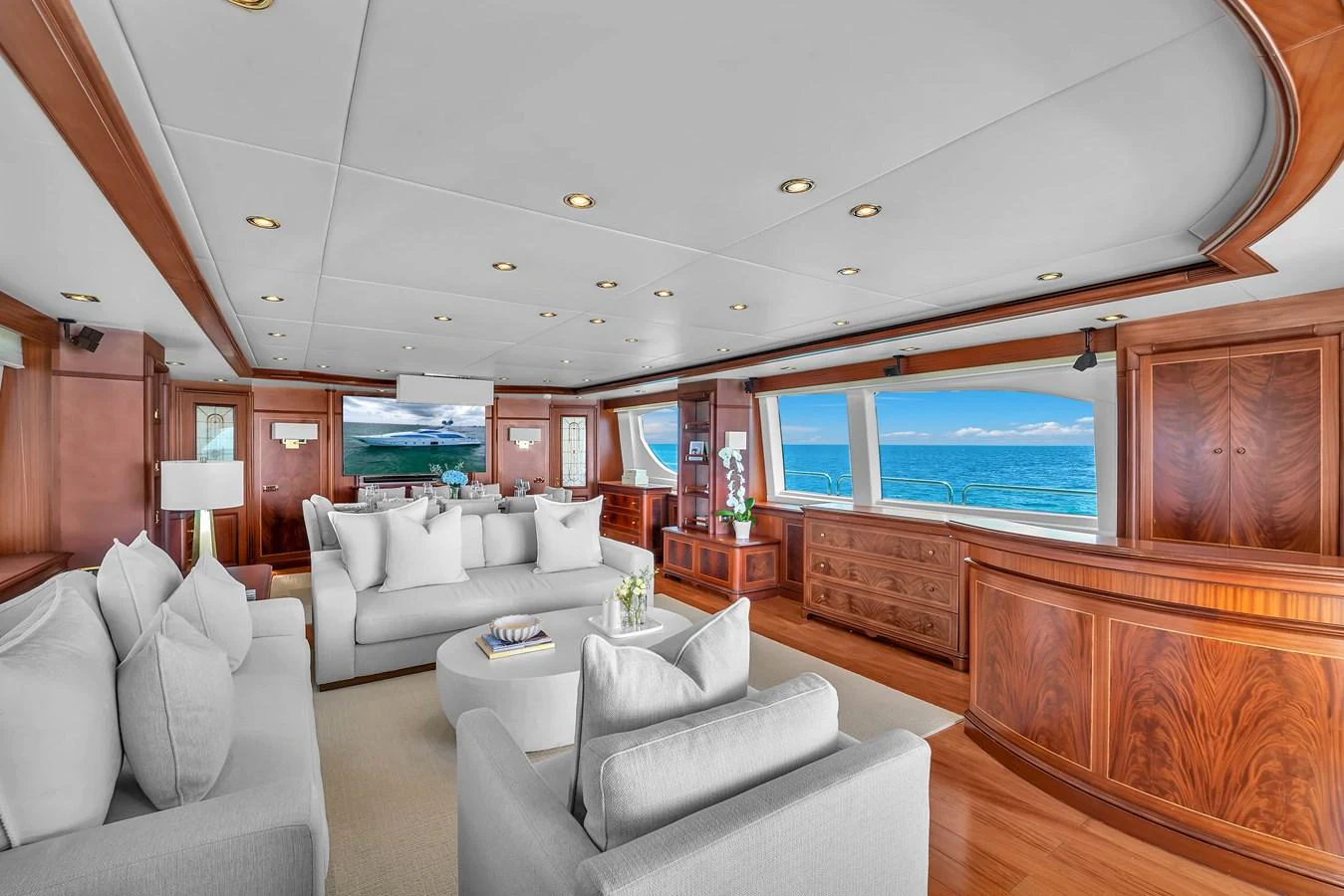 The salon features elegant wood paneling, plush seating, and expansive windows offering stunning ocean views. aboard AZIMUT GRANDE 105 Yacht for Sale