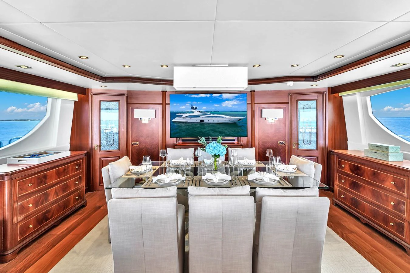The luxurious dining area features elegant seating and a large table, complemented by rich wood finishes and ocean views. aboard AZIMUT GRANDE 105 Yacht for Sale