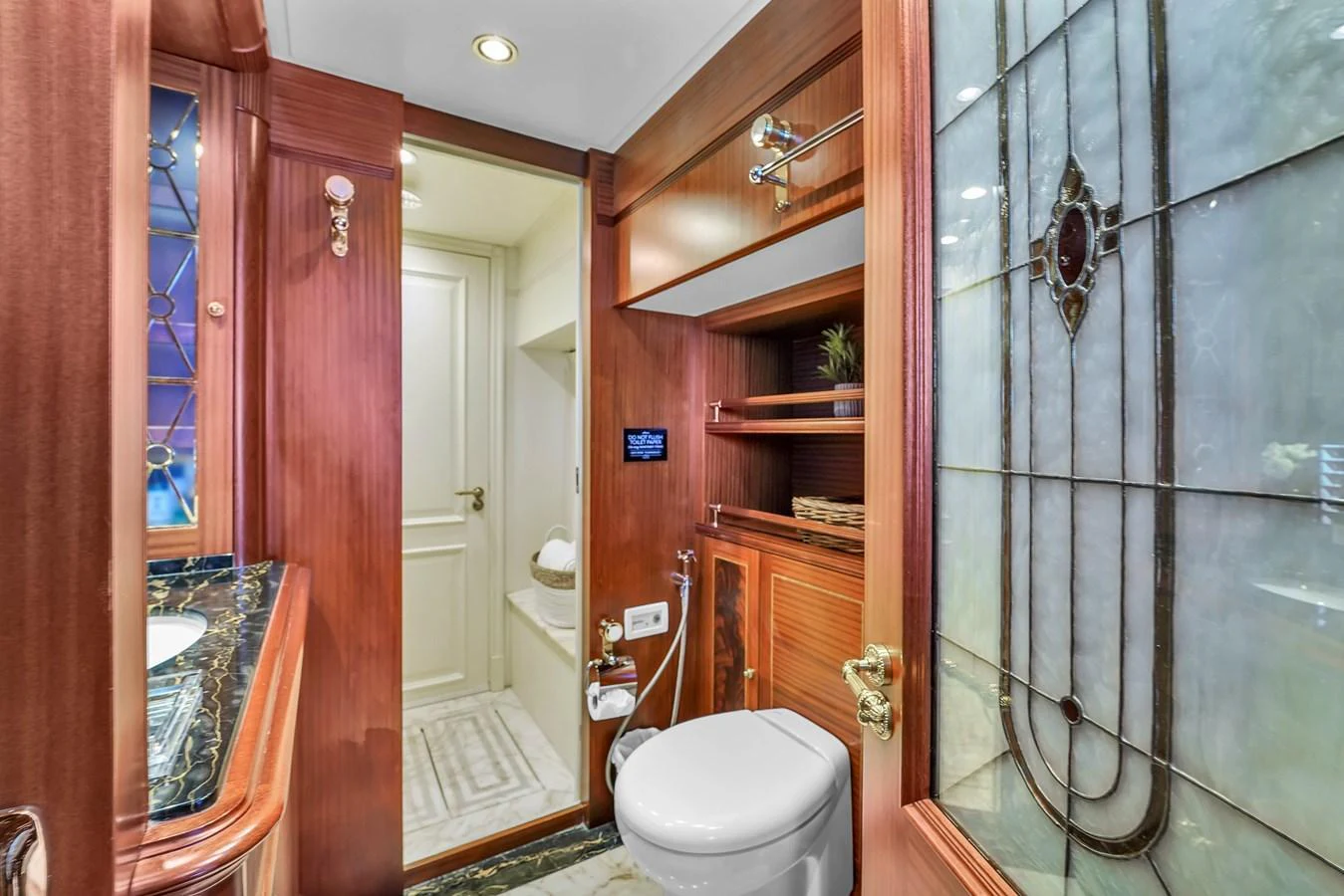 The yacht's bathroom features elegant wood paneling and a luxurious marble countertop. aboard AZIMUT GRANDE 105 Yacht for Sale
