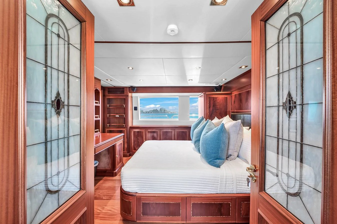 The master stateroom features elegant wood paneling and a large bed with plush pillows, offering a luxurious retreat. aboard AZIMUT GRANDE 105 Yacht for Sale