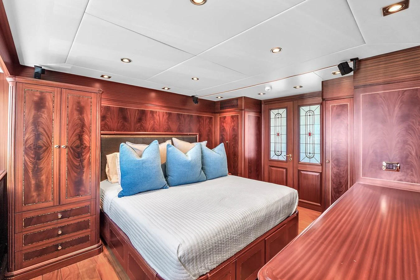 The master stateroom features luxurious wood paneling and a spacious bed adorned with plush pillows. aboard AZIMUT GRANDE 105 Yacht for Sale