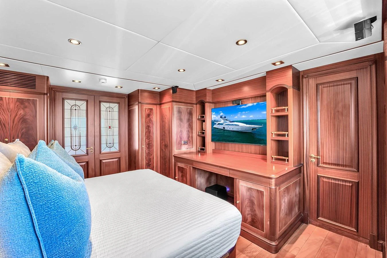The stateroom features elegant wood paneling, a large bed, and a flat-screen TV for ultimate comfort. aboard AZIMUT GRANDE 105 Yacht for Sale