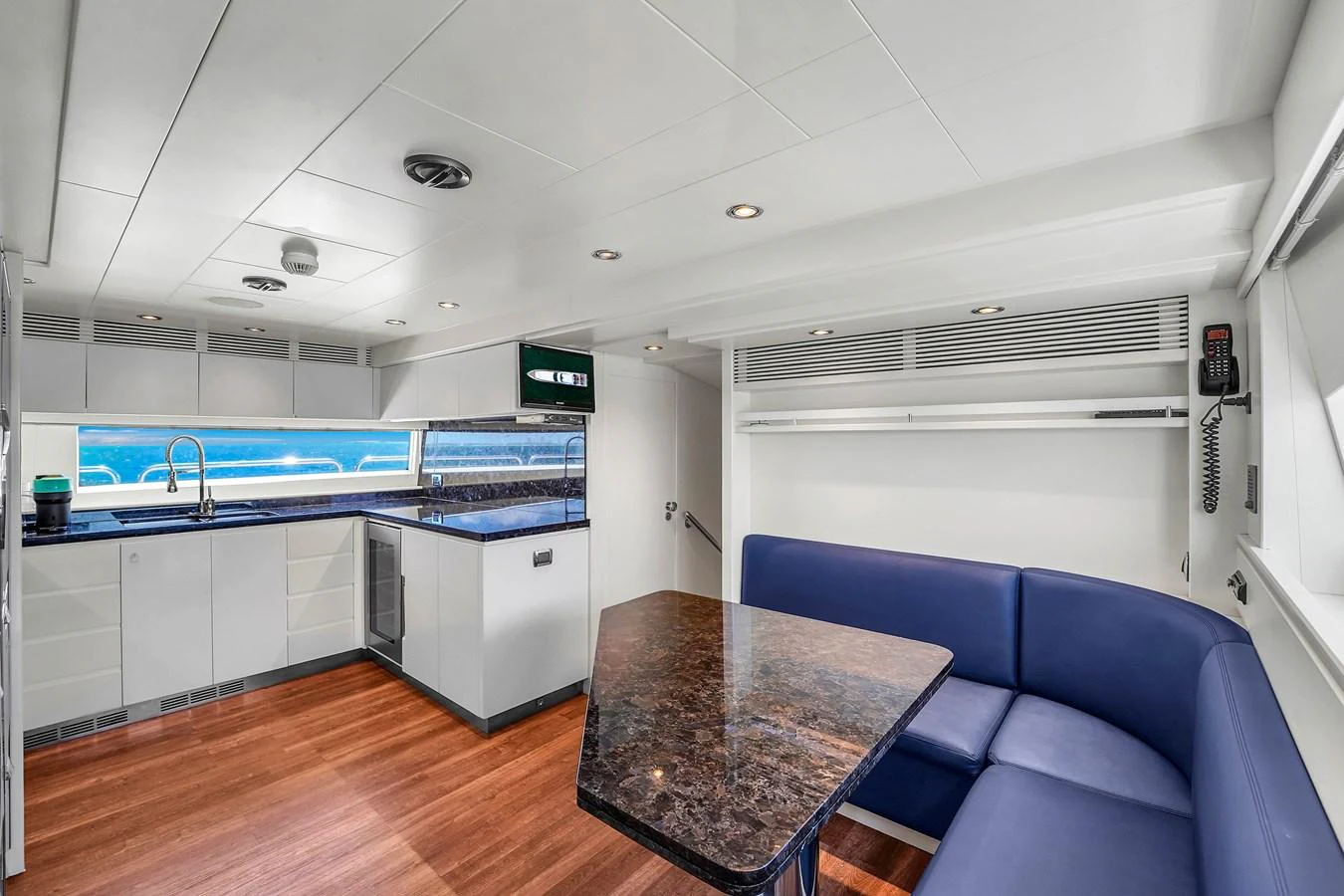 The yacht's galley features a sleek design with modern appliances and a comfortable dining area. aboard AZIMUT GRANDE 105 Yacht for Sale
