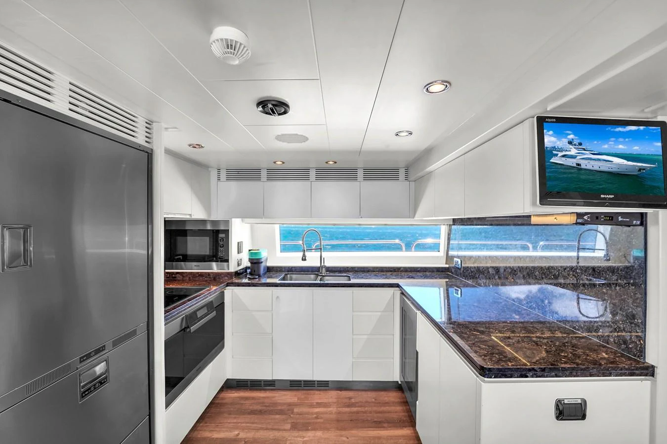 The yacht's galley features modern appliances and a sleek design with a view of the sea. aboard AZIMUT GRANDE 105 Yacht for Sale