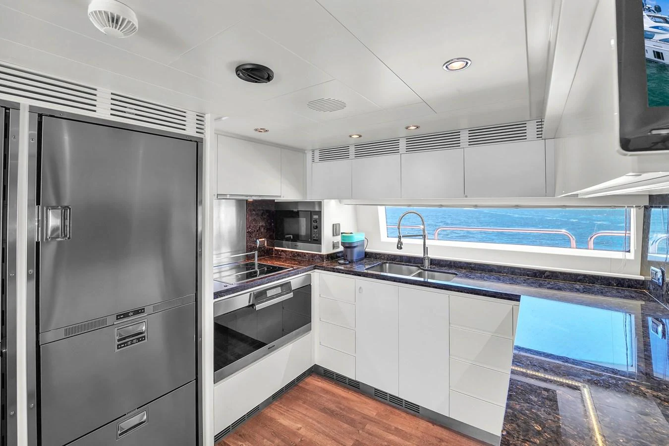 The modern galley features sleek appliances and a stunning ocean view through large windows. aboard AZIMUT GRANDE 105 Yacht for Sale