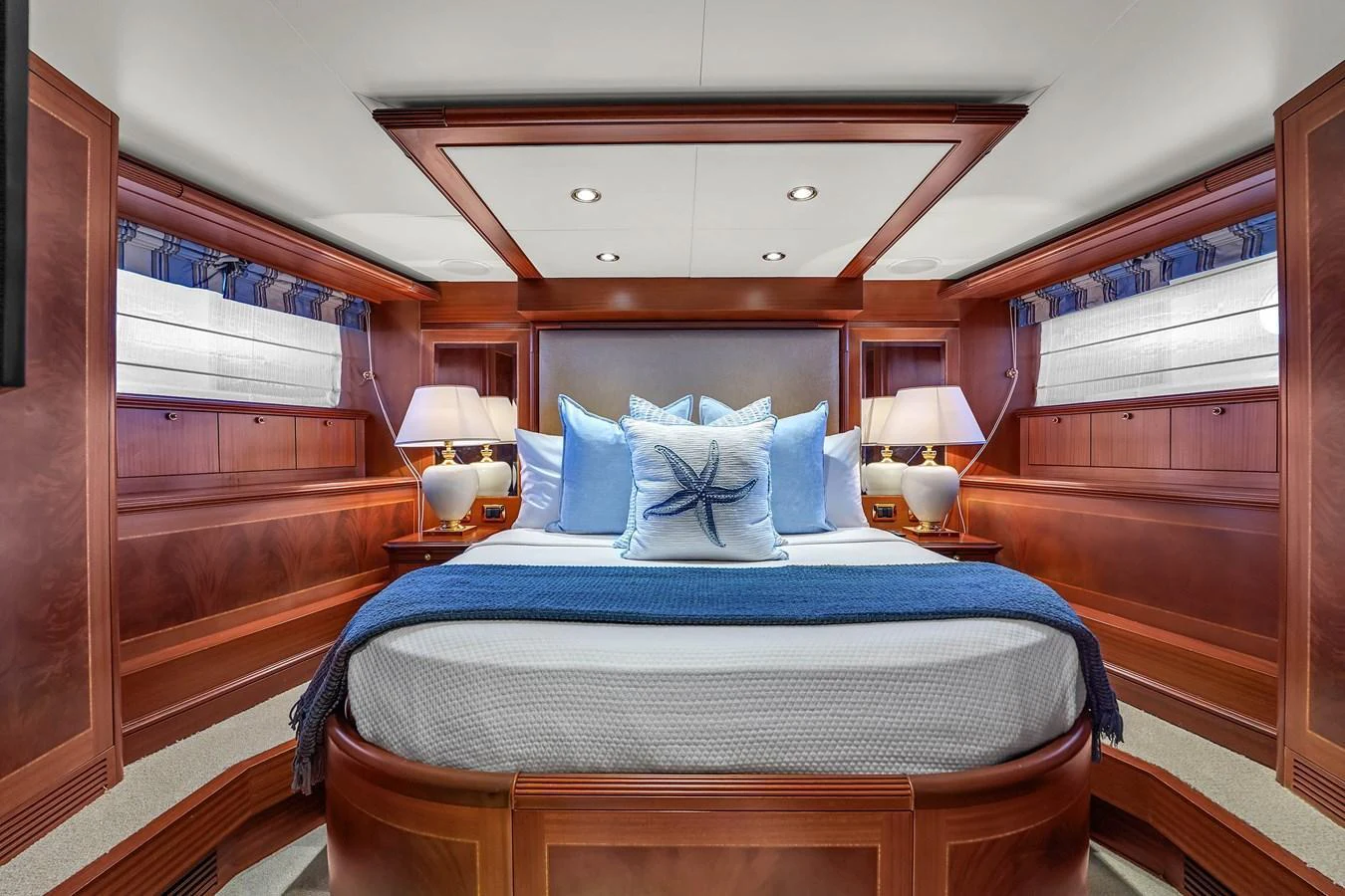 The master stateroom features elegant wood paneling and plush bedding, creating a luxurious and inviting atmosphere. aboard AZIMUT GRANDE 105 Yacht for Sale