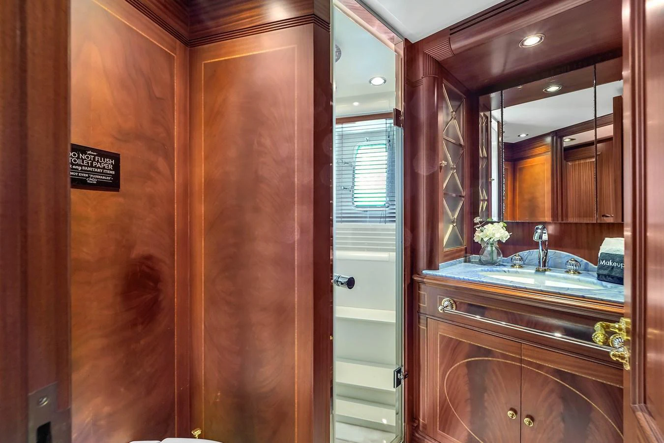 A luxurious yacht bathroom featuring rich wood paneling and elegant fixtures. aboard AZIMUT GRANDE 105 Yacht for Sale