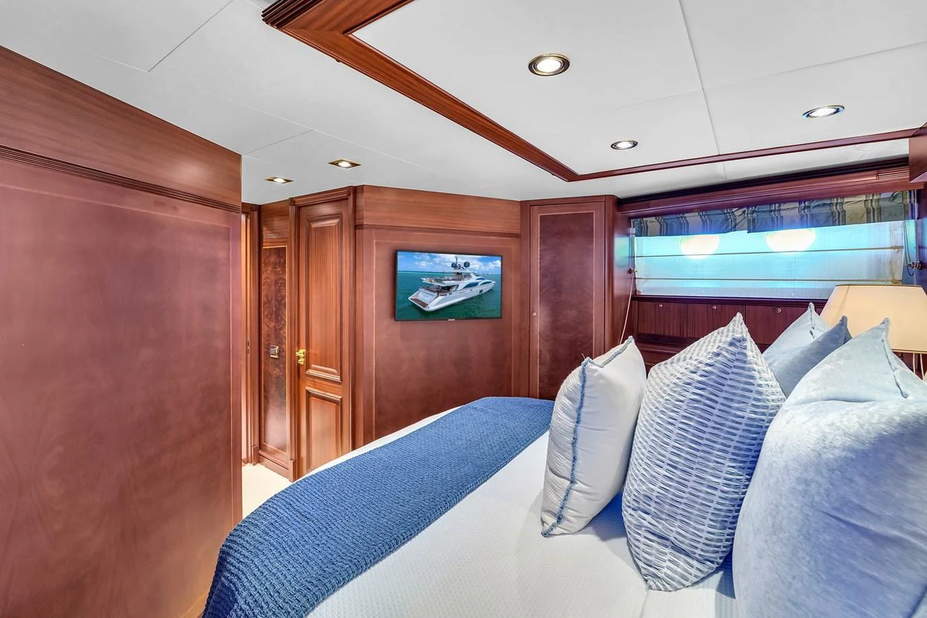 The stateroom features a cozy bed with plush pillows and elegant wooden paneling. aboard AZIMUT GRANDE 105 Yacht for Sale
