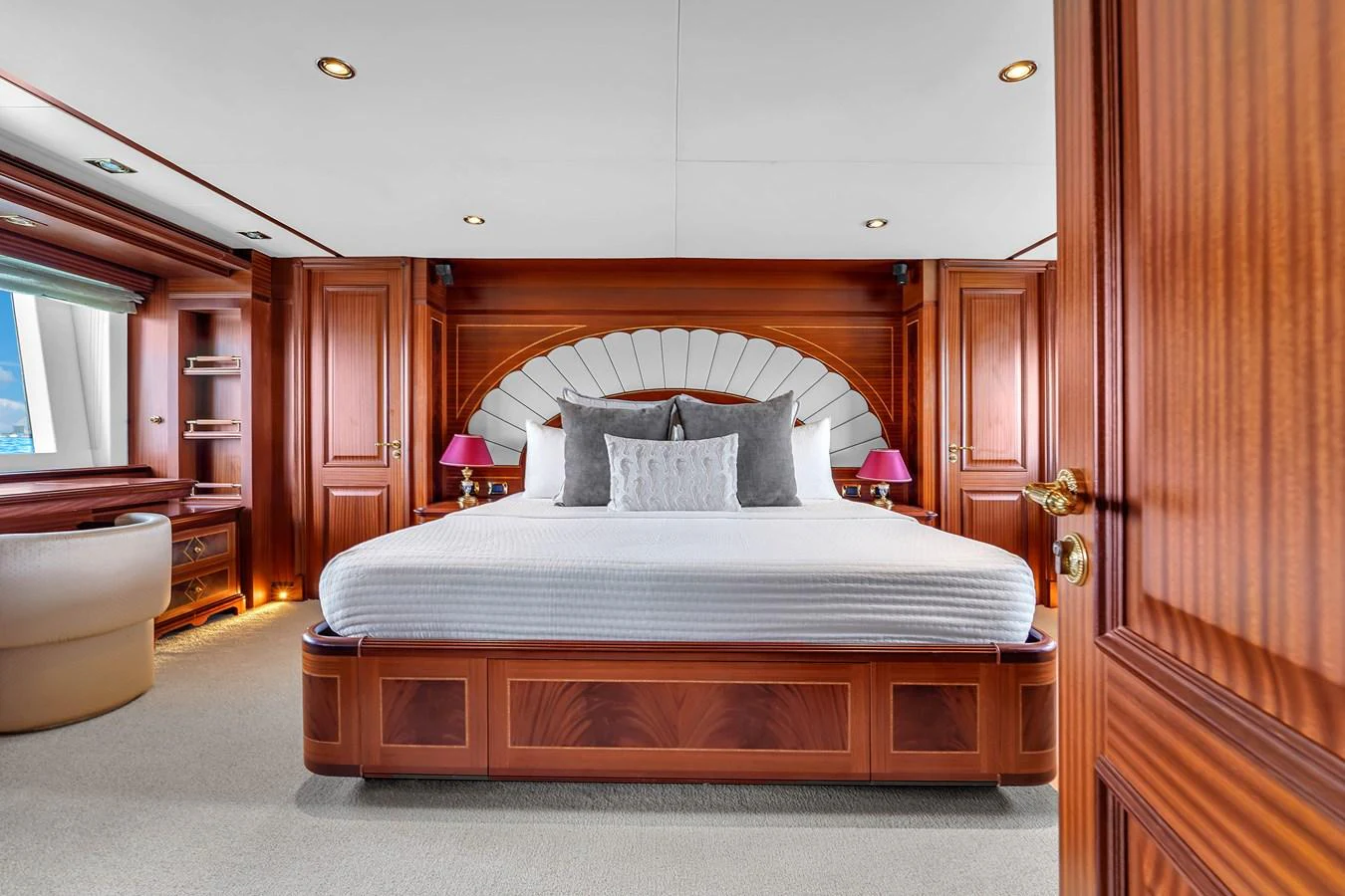 The master stateroom features a luxurious bed with elegant wood paneling and ample natural light. aboard AZIMUT GRANDE 105 Yacht for Sale