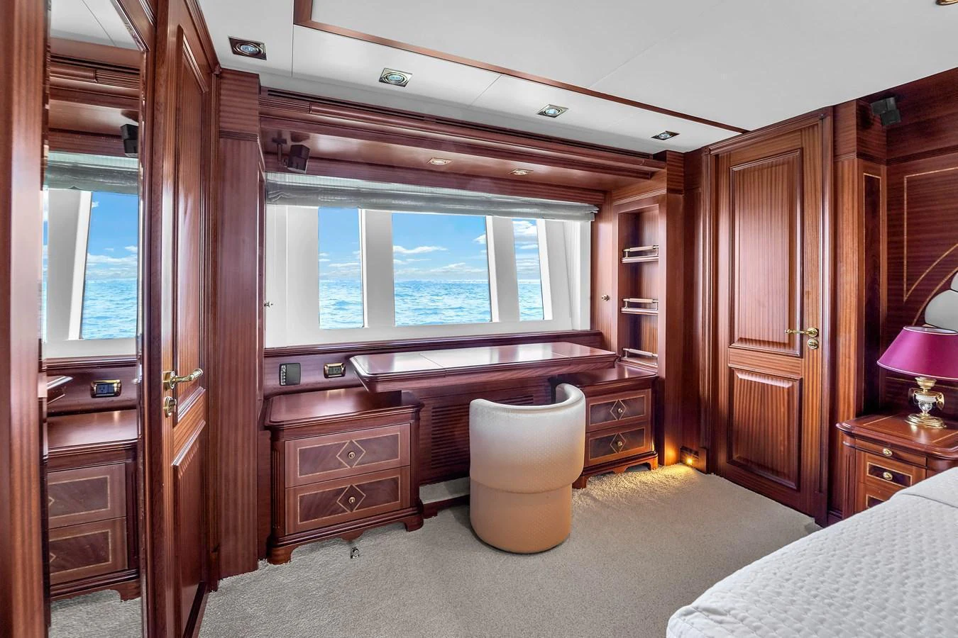 A luxurious stateroom with rich wood paneling and a stunning ocean view through large windows. aboard AZIMUT GRANDE 105 Yacht for Sale