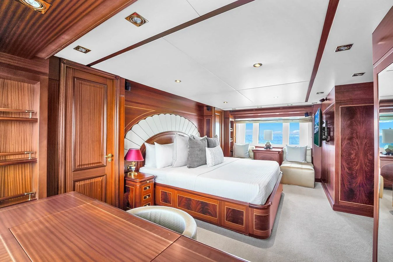 The master stateroom features luxurious wood paneling and a spacious, well-lit layout with large windows offering stunning views. aboard AZIMUT GRANDE 105 Yacht for Sale