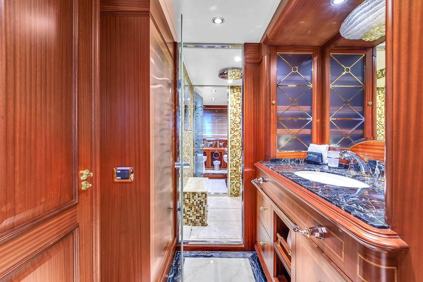 The yacht's bathroom features luxurious wood paneling, a marble countertop, and elegant fixtures. aboard AZIMUT GRANDE 105 Yacht for Sale