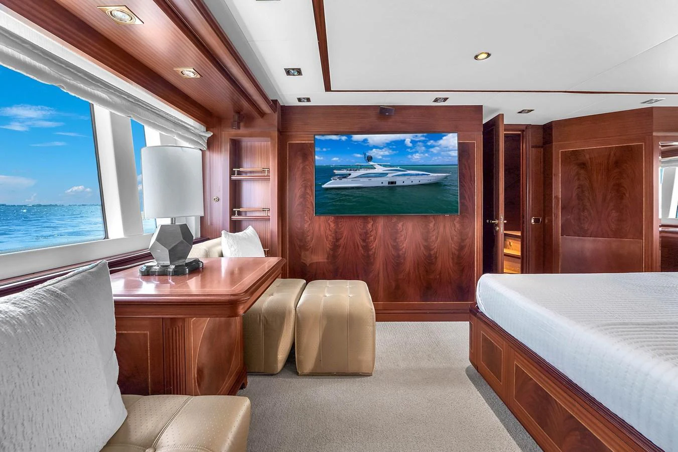 A luxurious stateroom with elegant wooden finishes and a large window offering a stunning sea view. aboard AZIMUT GRANDE 105 Yacht for Sale