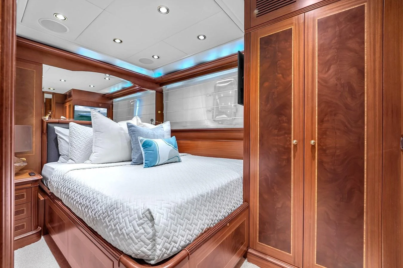 The stateroom features a luxurious bed with elegant wooden cabinetry and soft ambient lighting. aboard AZIMUT GRANDE 105 Yacht for Sale