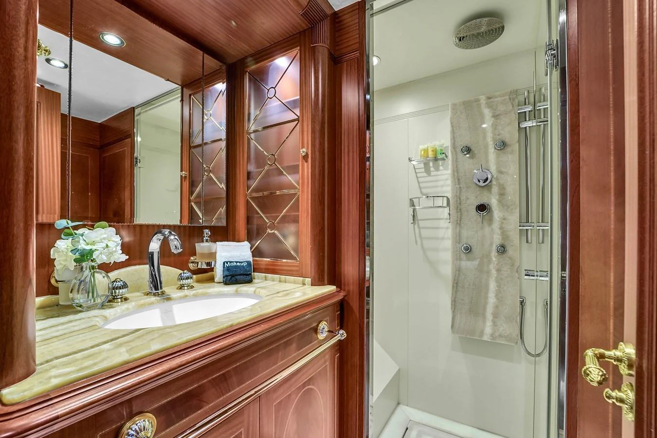 The yacht's bathroom features elegant wood cabinetry and a modern shower area. aboard AZIMUT GRANDE 105 Yacht for Sale