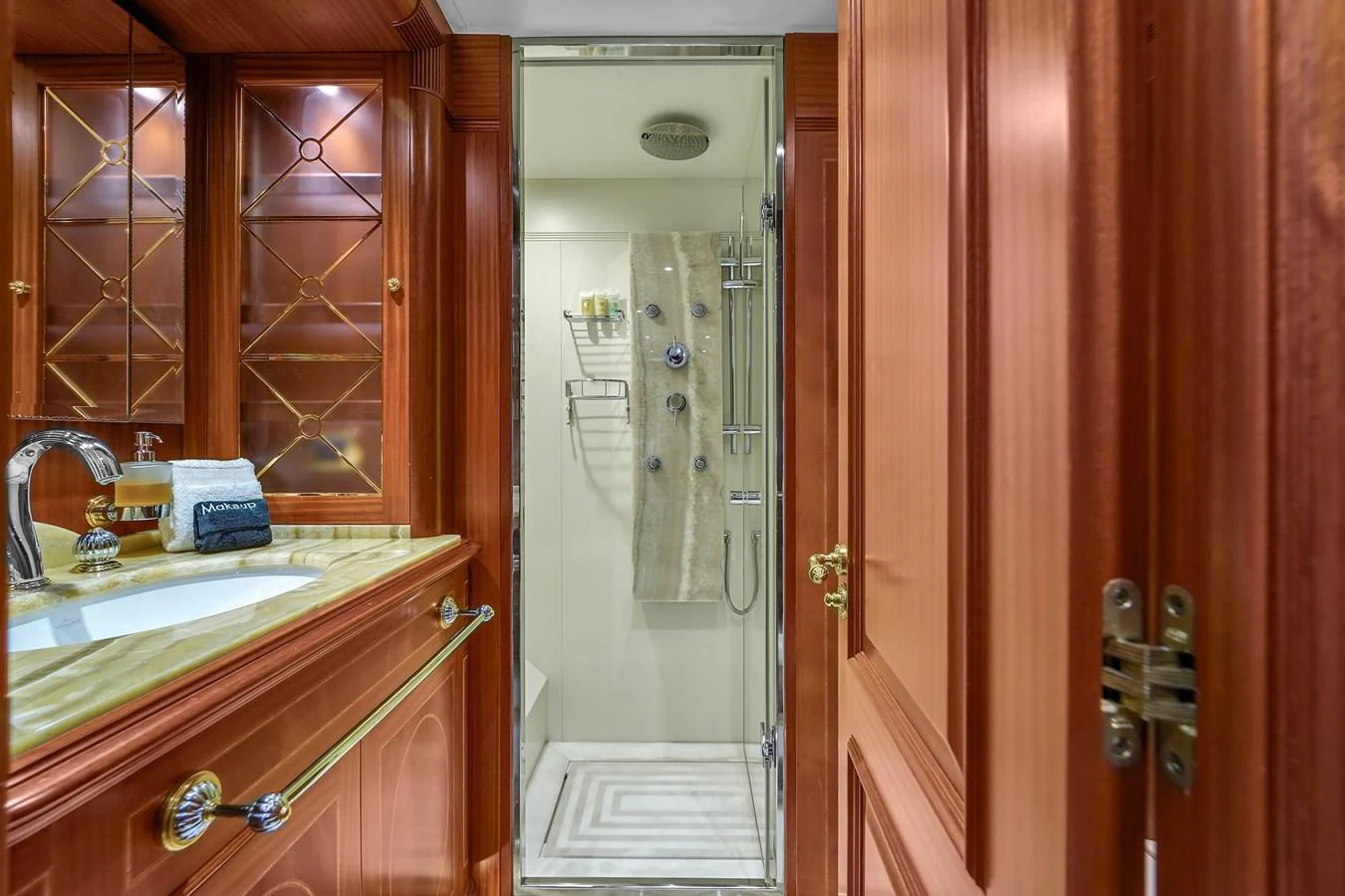 The yacht's bathroom features elegant wooden cabinetry and a modern shower area. aboard AZIMUT GRANDE 105 Yacht for Sale