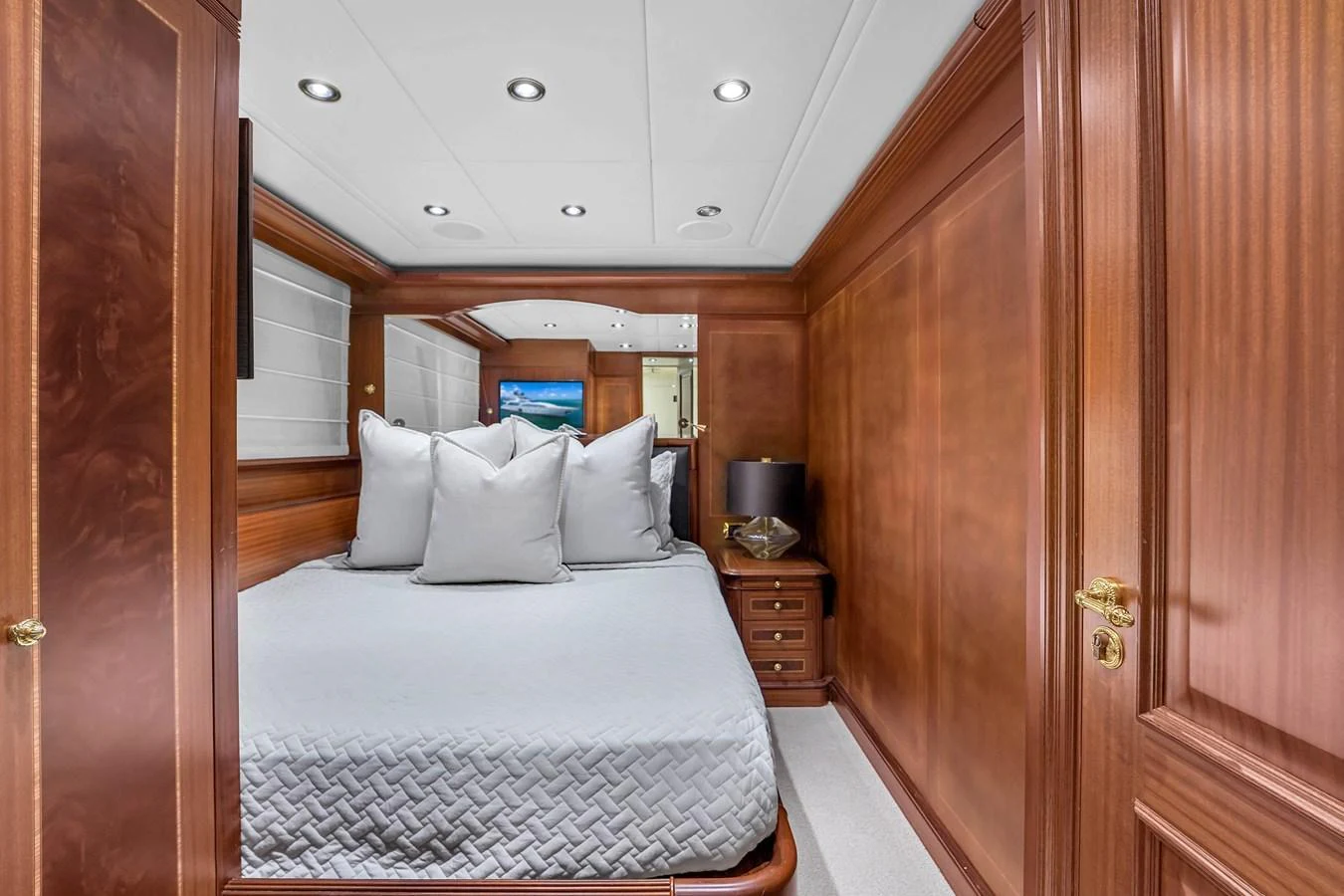 This cozy stateroom features a comfortable bed with plush pillows and elegant wooden paneling. aboard AZIMUT GRANDE 105 Yacht for Sale