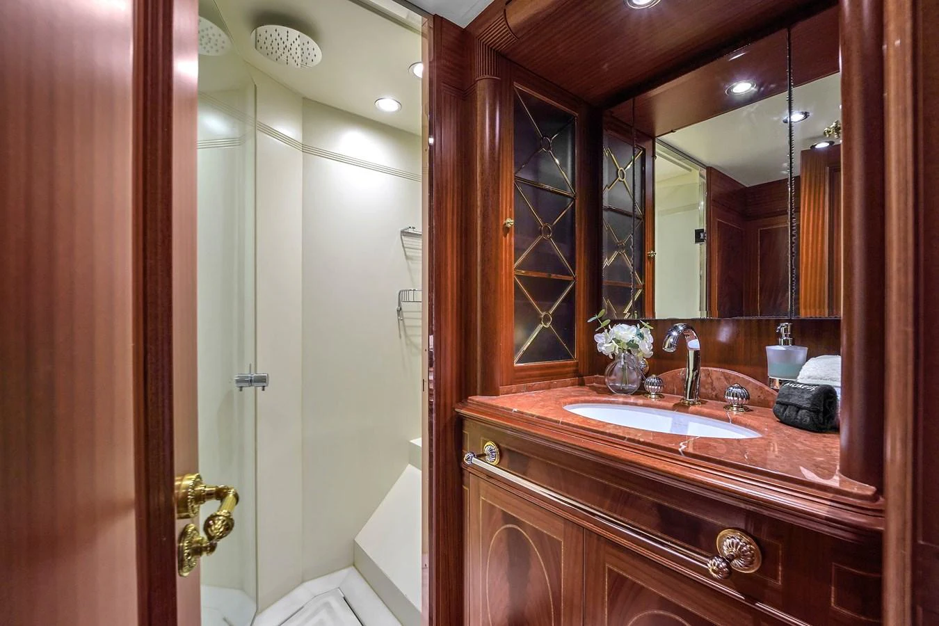 The yacht's bathroom features elegant wood cabinetry and a spacious shower. aboard AZIMUT GRANDE 105 Yacht for Sale