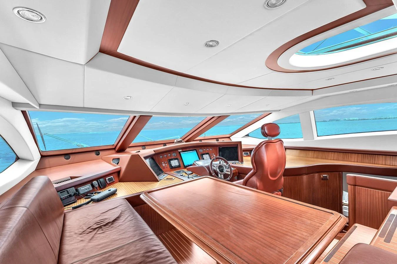 The yacht's helm features luxurious wood finishes and state-of-the-art navigation equipment, offering a commanding view of the sea. aboard AZIMUT GRANDE 105 Yacht for Sale