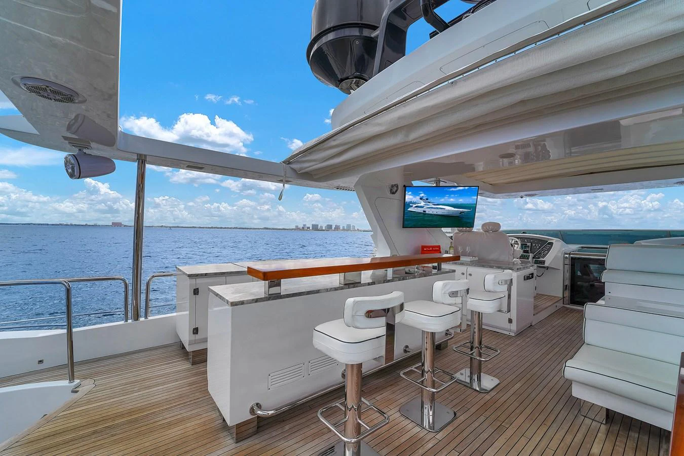 The flybridge offers a luxurious outdoor seating area with a bar and stunning ocean views. aboard AZIMUT GRANDE 105 Yacht for Sale