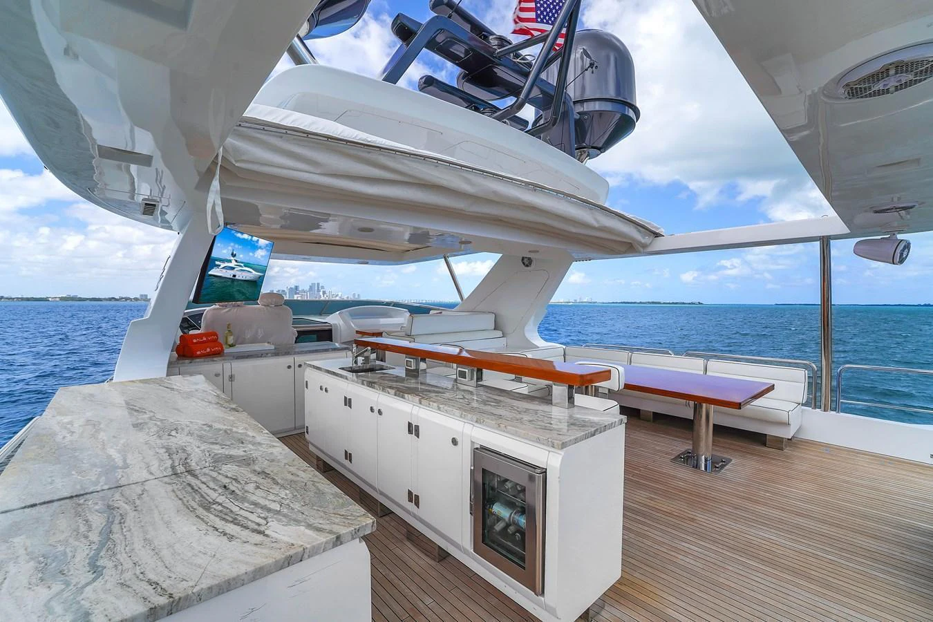 The aft deck features a spacious outdoor kitchen and dining area with stunning ocean views. aboard AZIMUT GRANDE 105 Yacht for Sale