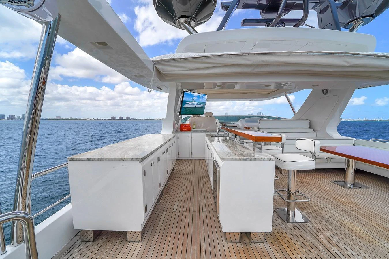 The flybridge features a spacious outdoor kitchen and bar area with ample seating, perfect for entertaining while enjoying panoramic ocean views. aboard AZIMUT GRANDE 105 Yacht for Sale