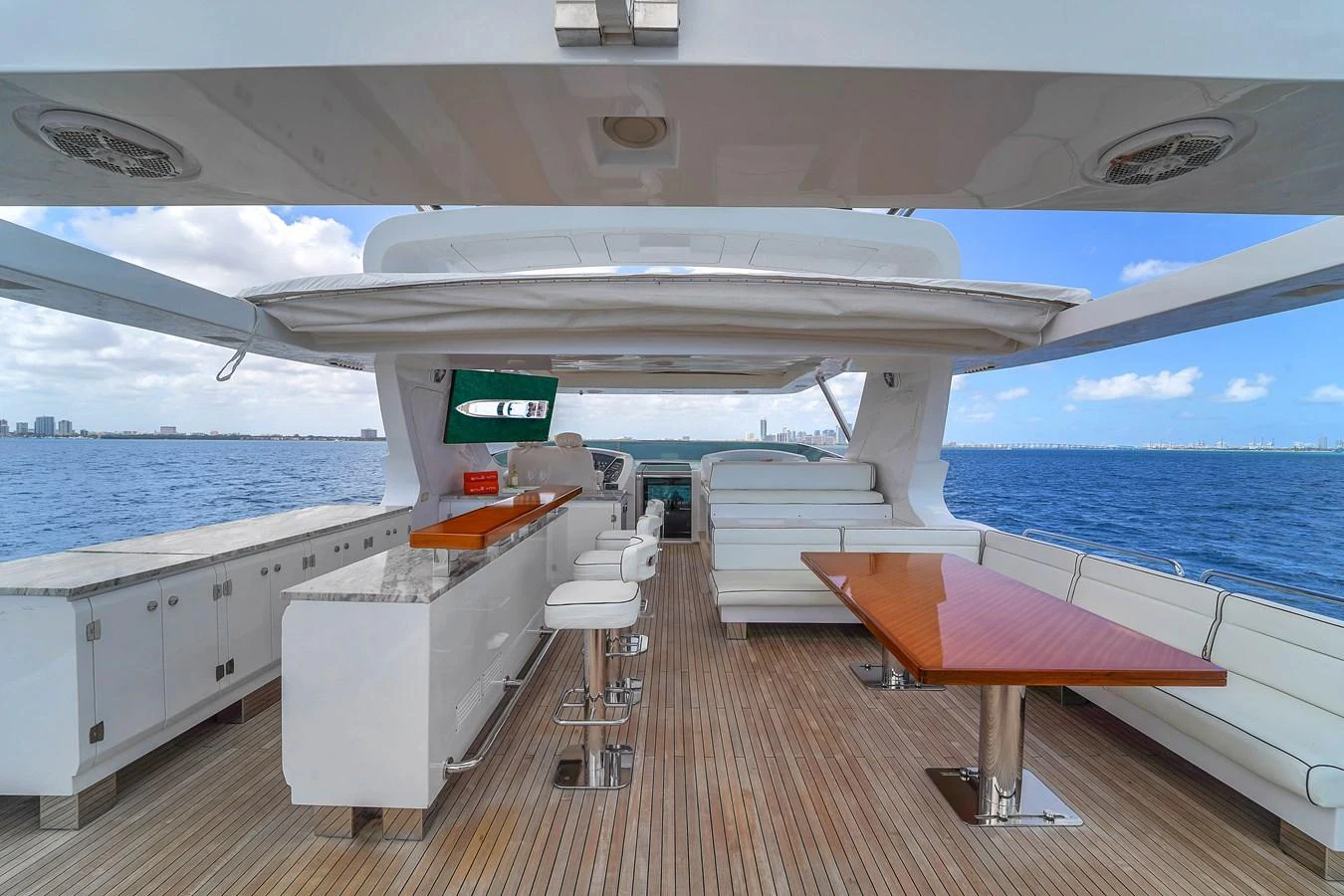 The aft deck features a spacious and stylish outdoor area with a bar and comfortable seating, perfect for entertaining while enjoying the ocean view. aboard AZIMUT GRANDE 105 Yacht for Sale