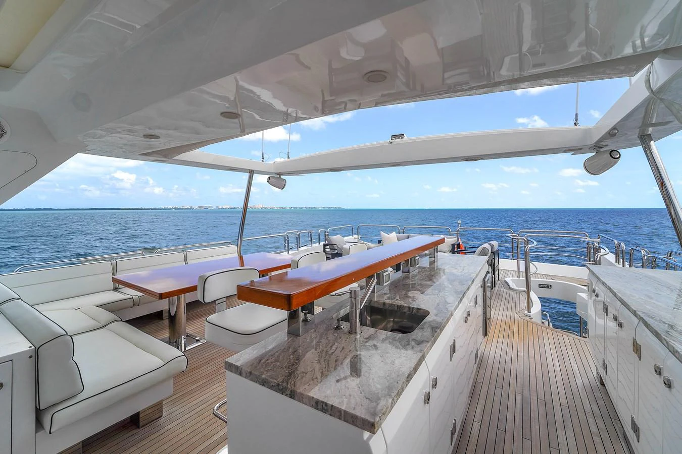 The aft deck features a spacious seating area with a bar and stunning ocean views. aboard AZIMUT GRANDE 105 Yacht for Sale