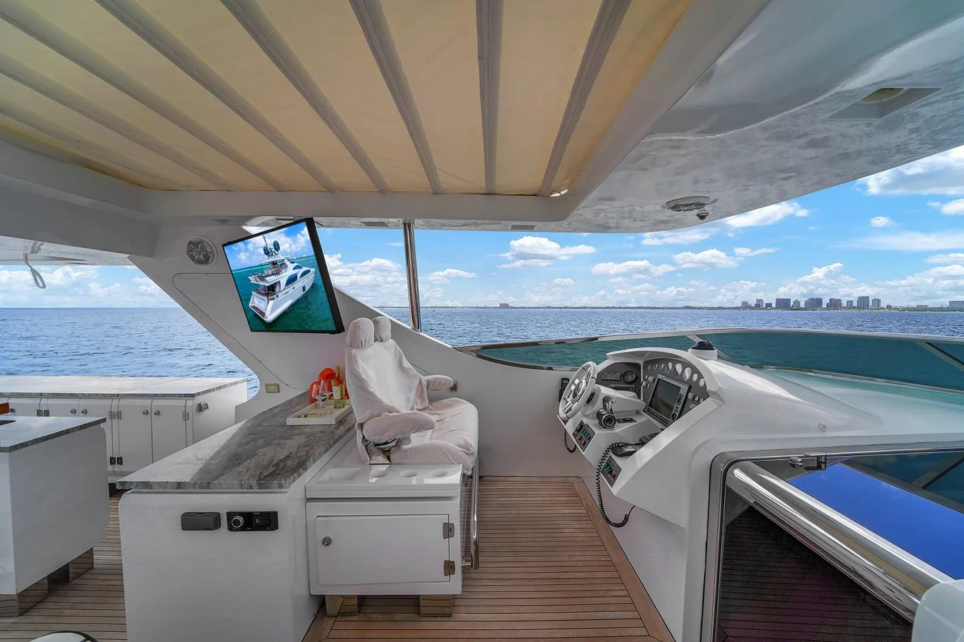 The helm area features a sleek design with modern controls and a comfortable captain's chair, offering a panoramic view of the sea. aboard AZIMUT GRANDE 105 Yacht for Sale