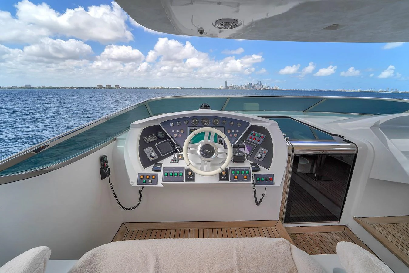 The helm station offers a commanding view of the open sea and city skyline. aboard AZIMUT GRANDE 105 Yacht for Sale
