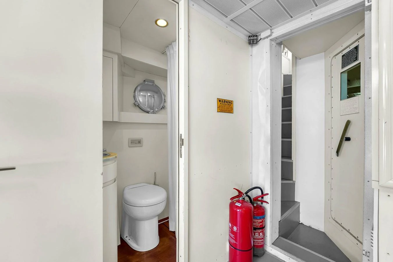 The image shows a yacht's interior with a bathroom and a staircase leading to another level. aboard AZIMUT GRANDE 105 Yacht for Sale