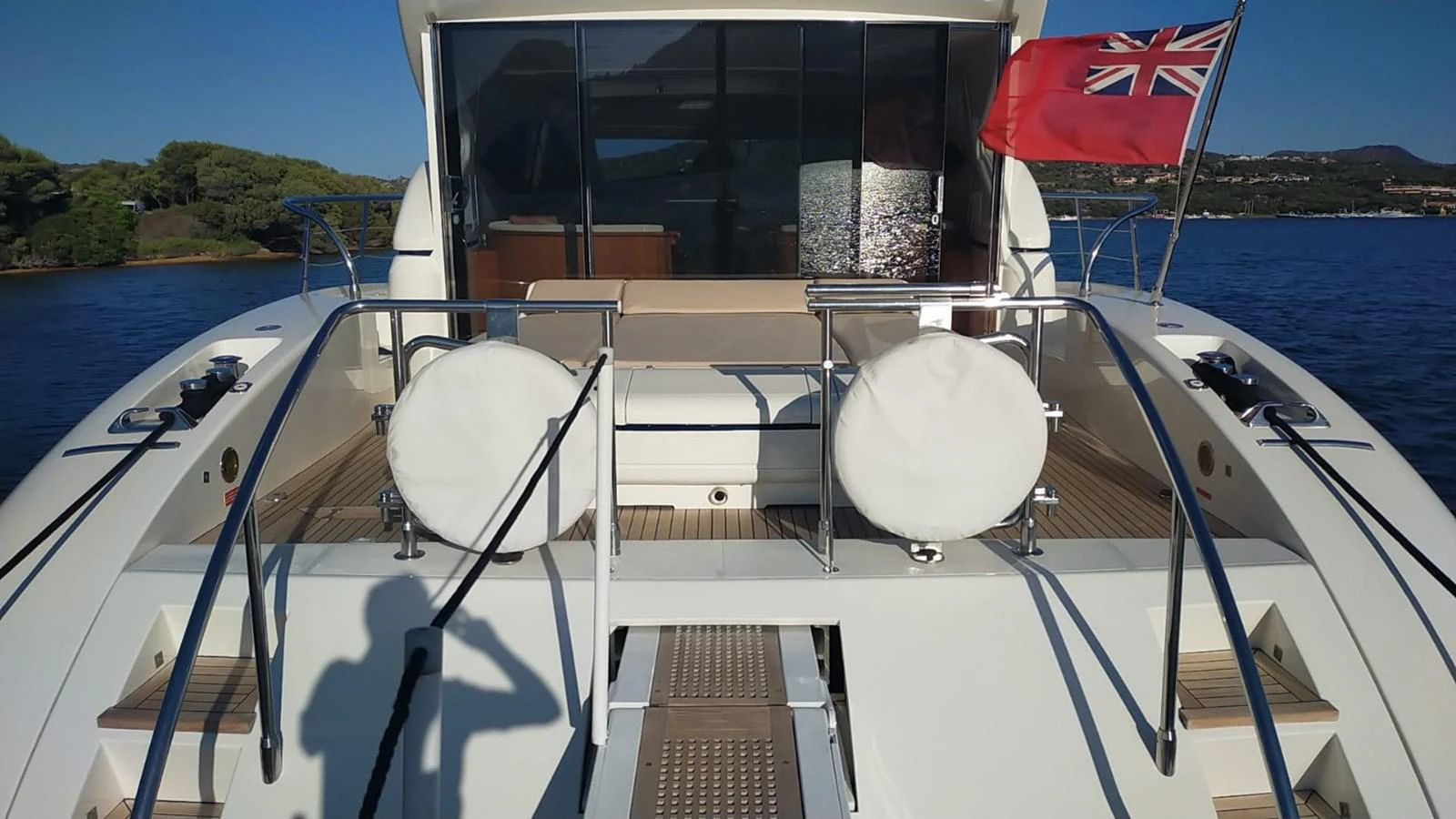 The yacht's aft deck features a spacious layout with comfortable seating and a flag proudly displayed. aboard SEVEN ZERO Yacht for Sale