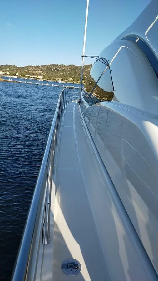 A sleek side deck of a yacht with a view of the water and distant shoreline. aboard SEVEN ZERO Yacht for Sale