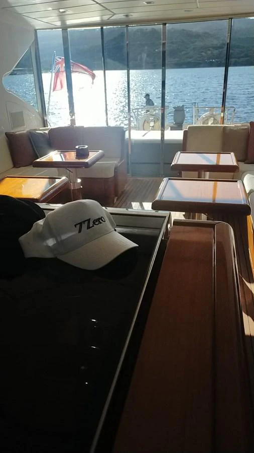 The yacht's salon offers a cozy seating area with a view of the water through large windows. aboard SEVEN ZERO Yacht for Sale