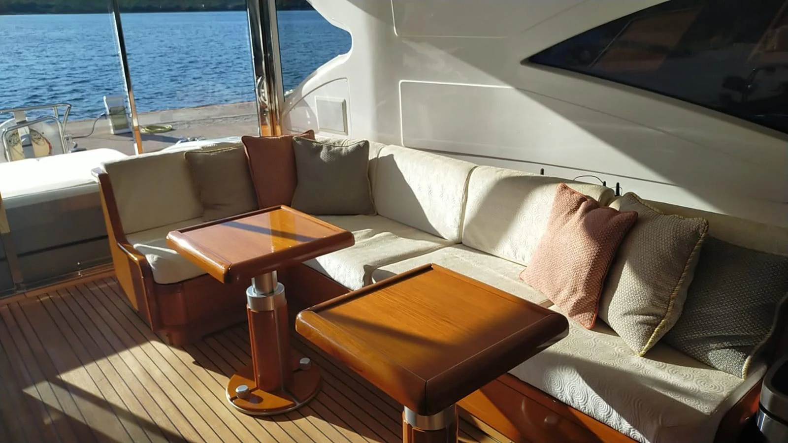 The aft deck features a cozy seating area with plush cushions and wooden tables, perfect for relaxation. aboard SEVEN ZERO Yacht for Sale