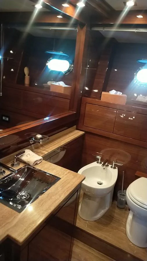 The yacht's bathroom features elegant wood finishes and modern fixtures, creating a luxurious and comfortable space. aboard SEVEN ZERO Yacht for Sale