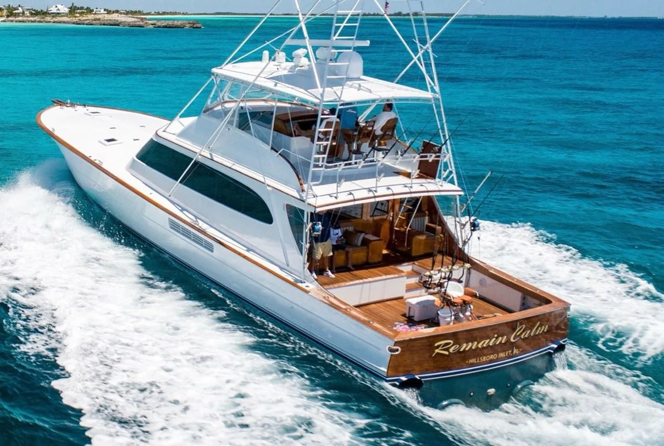 A sleek yacht cruises through clear blue waters, showcasing its elegant design and spacious deck. aboard REMAIN CALM Yacht for Sale