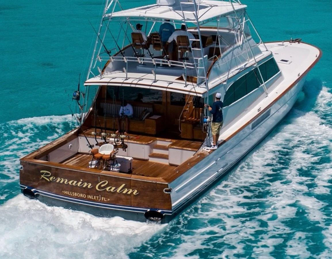 A sleek yacht cruises through turquoise waters, showcasing its spacious aft deck and elegant design. aboard REMAIN CALM Yacht for Sale