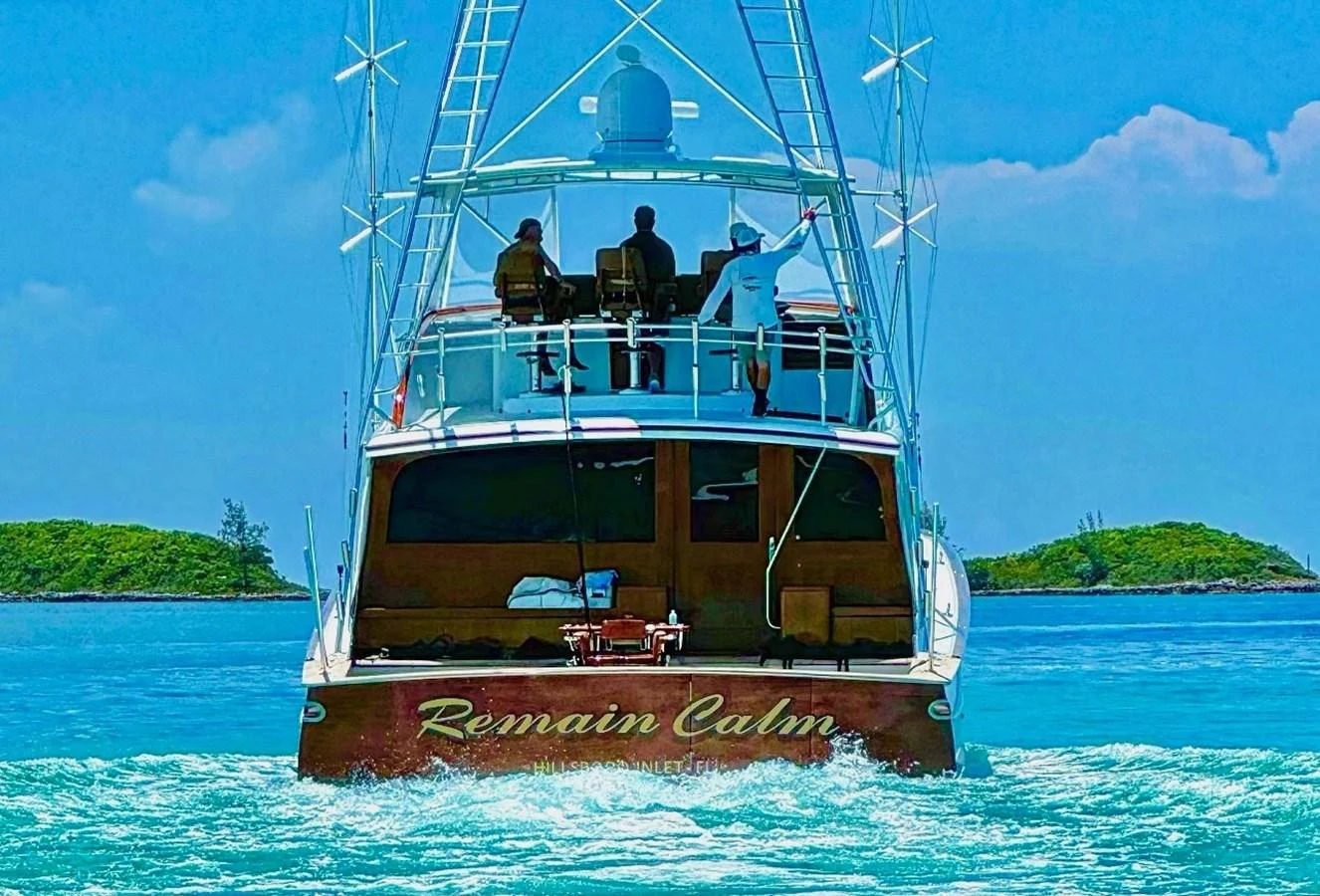 A luxurious yacht cruises through clear blue waters, showcasing its elegant design and inviting deck space. aboard REMAIN CALM Yacht for Sale