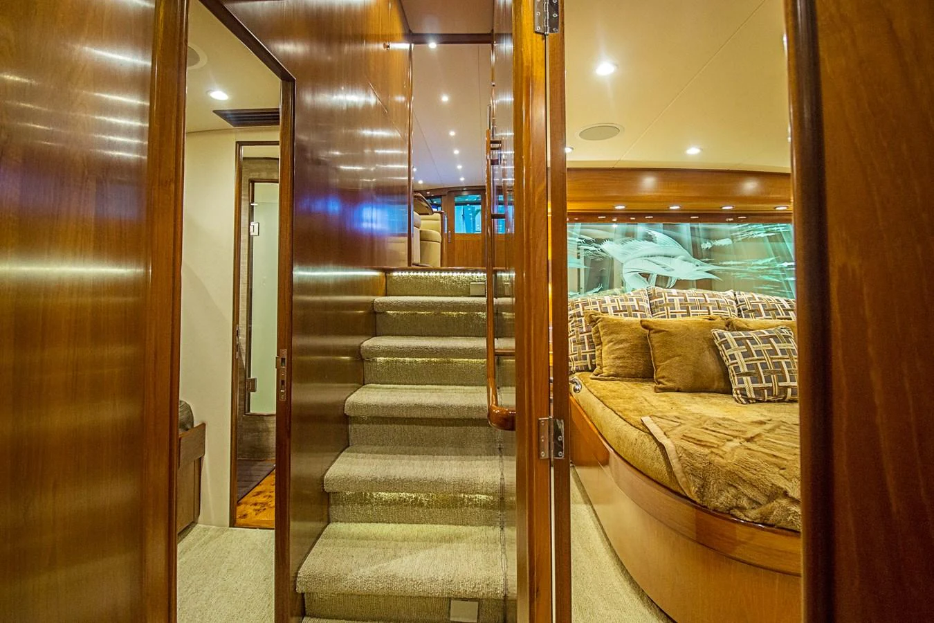 The image showcases a luxurious stateroom with plush bedding and elegant wooden finishes. aboard REMAIN CALM Yacht for Sale