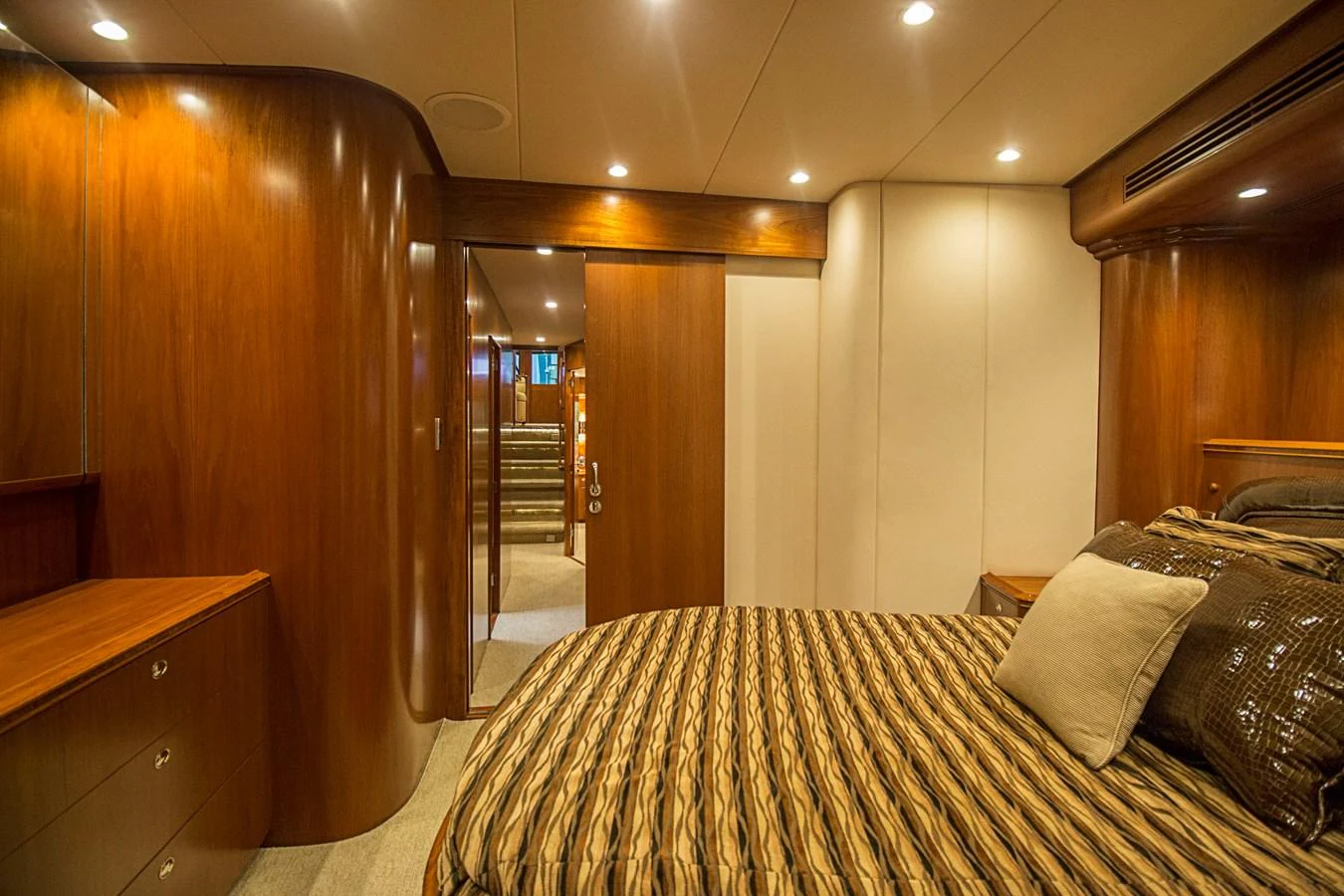 A luxurious stateroom with rich wood paneling and elegant bedding. aboard REMAIN CALM Yacht for Sale