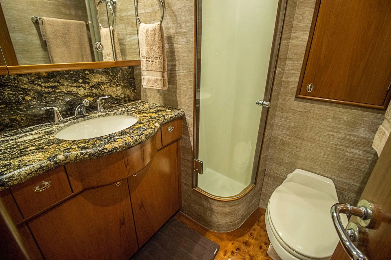 The yacht's bathroom features a sleek design with a granite countertop and a glass-enclosed shower. aboard REMAIN CALM Yacht for Sale